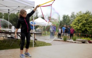 Girl playing with giant bubble wand