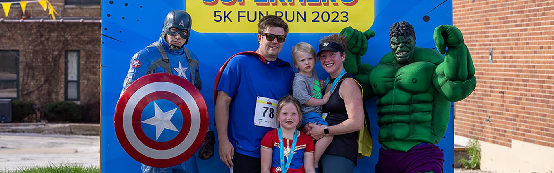 Fun Run participants pose with superhero characters - Photo by Kasey Mueller