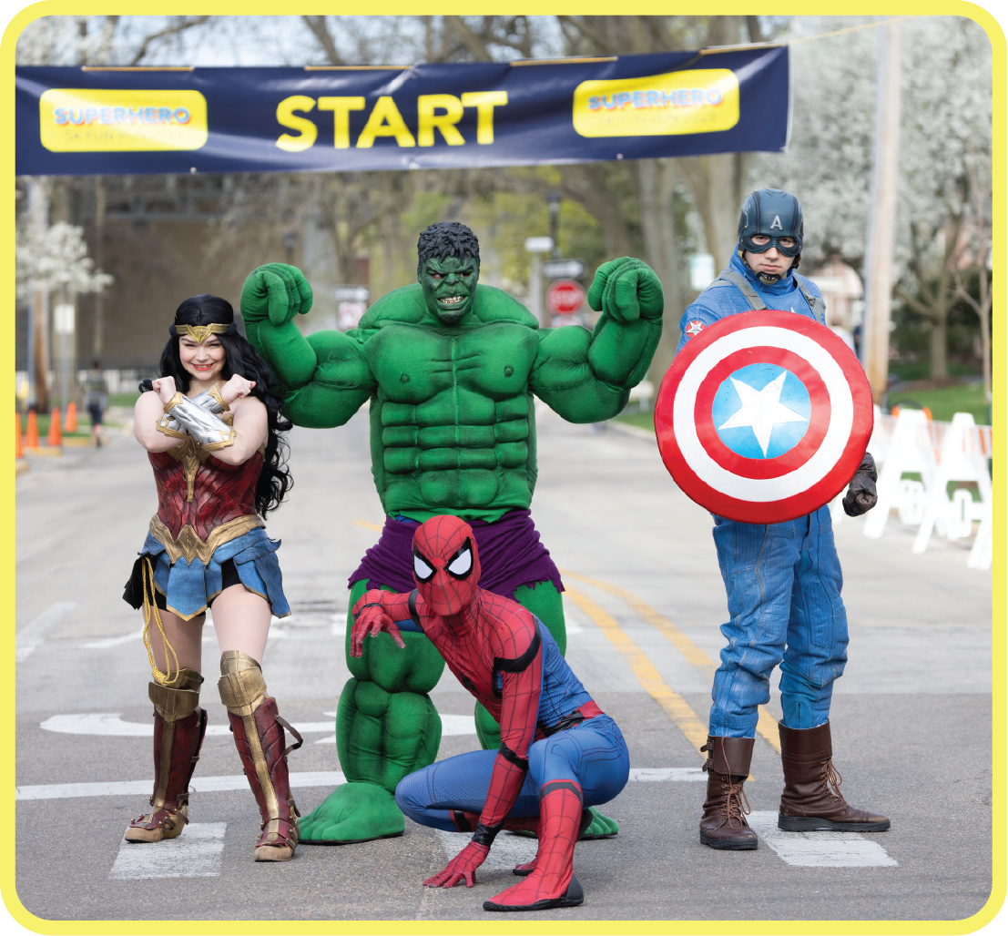 Superheroes posing with starting line in the background