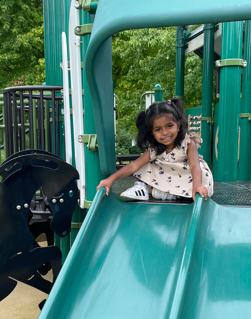 IMG_0003 Little girl smiling before sliding down the slide